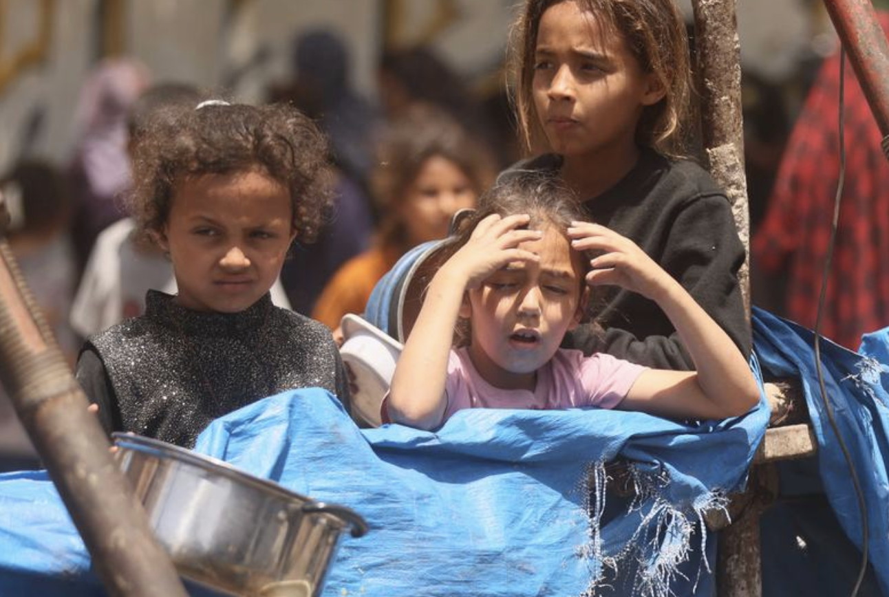 Niños de Gaza esperan recibir alimentos en medio de la crisis humanitaria.